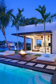 Une cheminée extérieure à côté d’une piscine design outdoor | Design Feria