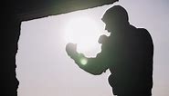 Download Silhouette of a boxer on a sunset background. Coaches punches. Shadow-boxing. Outdoor workout. Motivational video. Theme of healthy lifestyle and sport. Martial arts. Boxing. Slow motion. for free