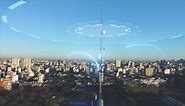 Premium stock video - Aerial orbit shot of 5g telecommunication towers cellular network antenna signal waves supply city with internet - digital glowing lines motion graphic during sunset and skyline in background