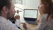 Free stock video - A young working team composed of two women and two men consulting financial results at the laptop in a work meeting