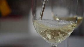 White wine pouring into a glass. Free HD slow motion video footage