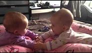 Twin babies talk and hold hands for the first time