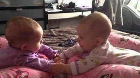 Twin babies talk and hold hands for the first time