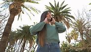 Free stock video - Worried young woman talking on phone in the street in a sunny day