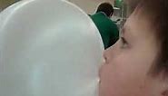 Bubble gum boy blows bubble art in a supermarket