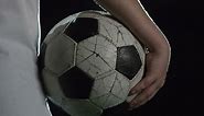 Free stock video - Camera focuses soccer ball held by boy illuminated by a spotlight at night