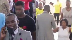 Moment African priest tries to claim he is on the phone to GOD mid-service
