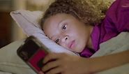 Free stock video - Closeup of cute girl lying in bed, swiping smartphone screen