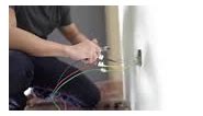 Close up. Asian Chinese male electrician connects the sockets to the...