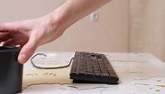 Man's Hand Turns Over the Keyboard and Shakes Out Drops of Spilled Coffee