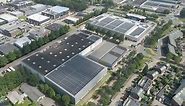 Aerial overview of industrial buildings with photovoltaic solar panels on rooftops