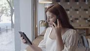 Free stock video - Serious pretty young woman talking on cellphone while holds a tablet