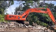 Hitachi Ex200 excavator unloads gabions
