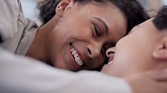 Love, bedroom and face of lesbian couple kiss, relax and care for marriage, non binary or homosexual partner. LGBTQ, comfort and happy people bonding, support and enjoy morning together in home bed