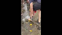 Tourist's slippers stuck to his ankle while spraying water at festival