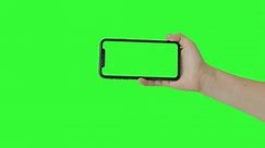 Woman hand holding the smartphone on green screen chroma key background. Mobile phone mock-up for your product. The iPhone 11 model in horizontal orientation landscape mode. 2020 - USA, NY