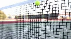 Tennis ball hits player net on tennis court