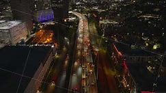 Vibrant city lights and bustling traffic of a Houston freeway at night with stunning aerial footage