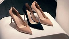 Ladies luxury beige and black high heeled shoes or stilettos stand on the shelf in a shoe store or boutique window