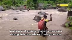 In absence of bridge, students cross river with help of rope