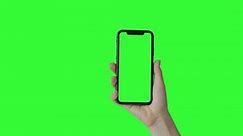 Woman hand holding the smartphone on green screen chroma key background. Mobile phone mock-up for your product. The iPhone Xr model in vertical orientation portrait mode. 2020 - USA, California