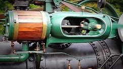 An old-fashioned steam engine tractor creates power to drive a pony saw mill.