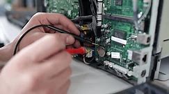 Close-up image of technician man hand measuring electrical voltage of computer mainboard by using digital multimeter. Maintenance and repair computer hardware service concept.
