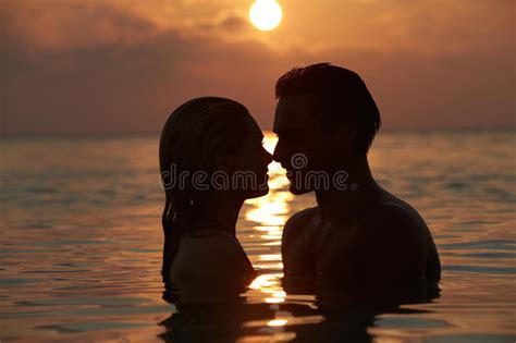silhouette of romantic couple standing in sea stock image