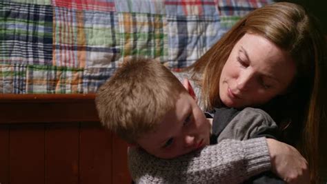 a mother comforts her son who looks sad stock video