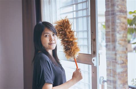 Mulher Asiática Que Usa Uma Escova Da Poeira Mãos Da Empregada