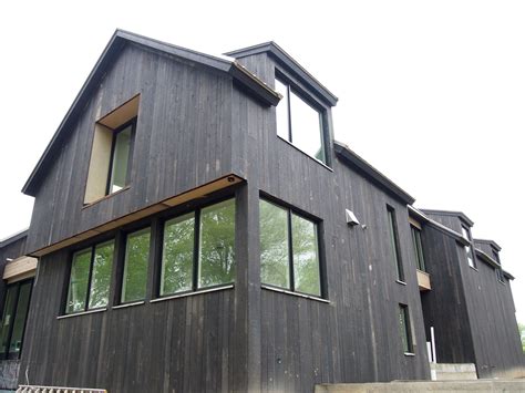 black vertical cedar siding  black clad windows house exterior