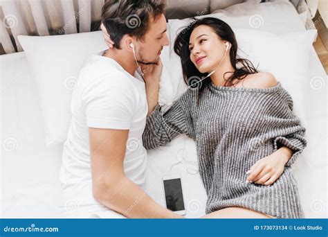 Adorable Smiling Woman Gently Stroking Husband`s Face Lying In Bed