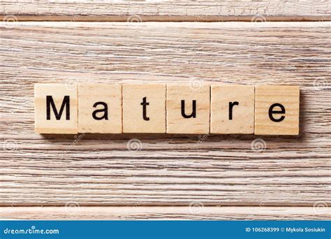 mature word written on wood block mature text on table concept stock