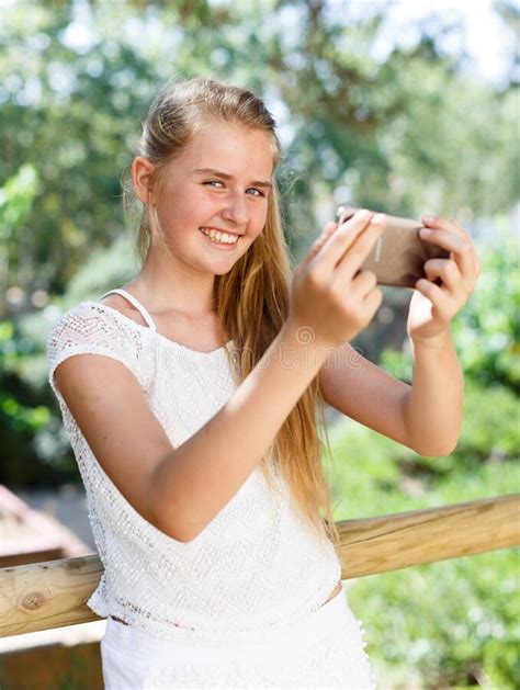 Portrait Of Teenage Cute Girl Making Photo With Smartphone At Sunny Day