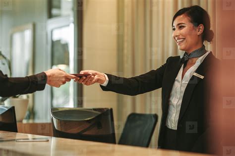 smiling receptionist attending hotel guest stock photo