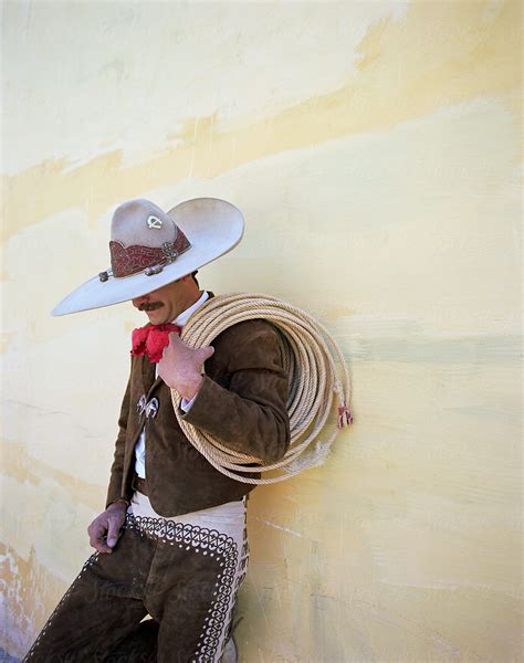 mexican cowboy leaning  wall  lasso  stocksy contributor hugh sitton stocksy