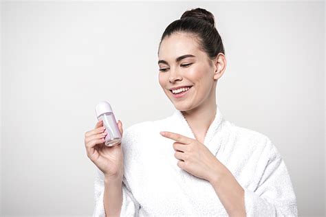 유토이미지 Happy Woman In Bathrobe Pointing With Finger At Deodorant