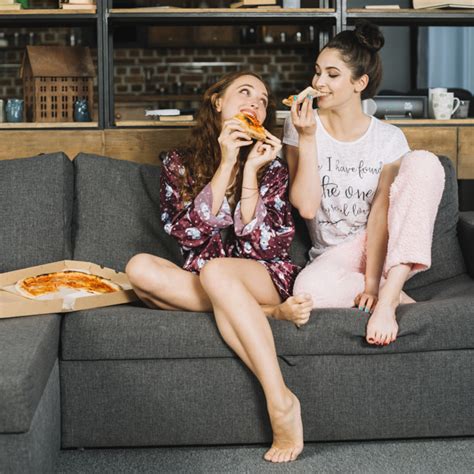 duas amigas comendo pizza em casa foto grátis