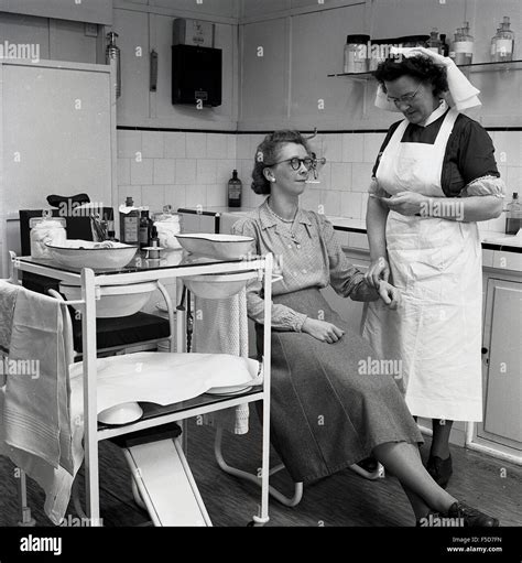 1950s Historical At A Doctors Or Gps Surgery A Female Patient Sits