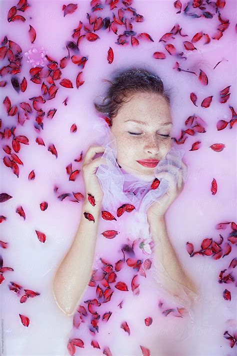 portrait of a beautiful redhead with freckles having a milk bath by