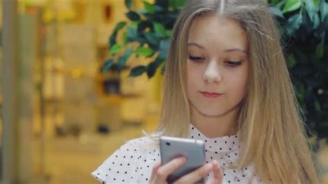 zbliżenie ładny dziewczyna 13 lat fotografuje siebie za pomocą smartfona selfie — wideo