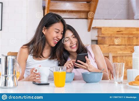 Happy Asian Lesbian Woman Couple Watching Morning News On