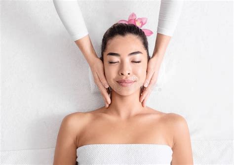 Spa Therapist Making Relaxing Head Massage For Beautiful Asian Woman In