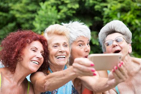 Four Mature Women Friends Taking A Selfie Outdoors By