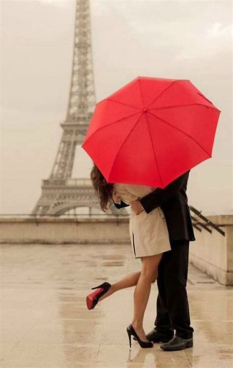 together kissing under the eiffel tower red umbrella