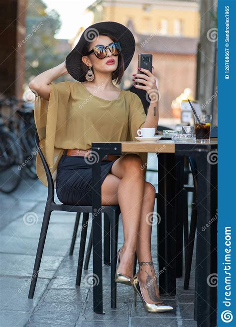 Elegant Italian Woman With Hat And Glasses Checks Her Makeup On Her