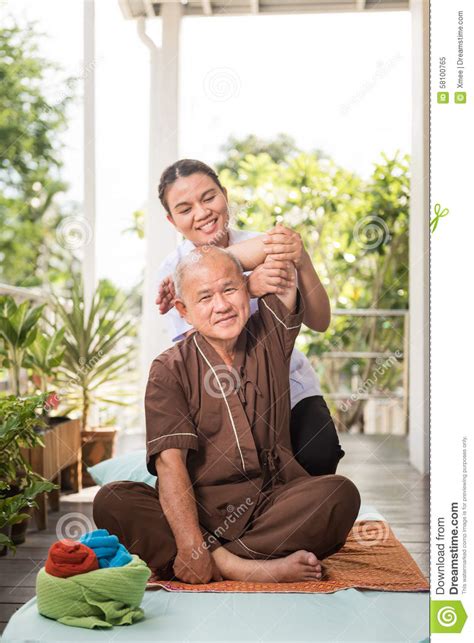 therapist giving massage to senior male patient stock