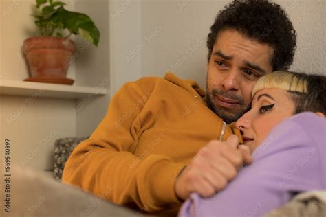 Biracial Couple Stretched Out On The Sofa Covered With The Blanket