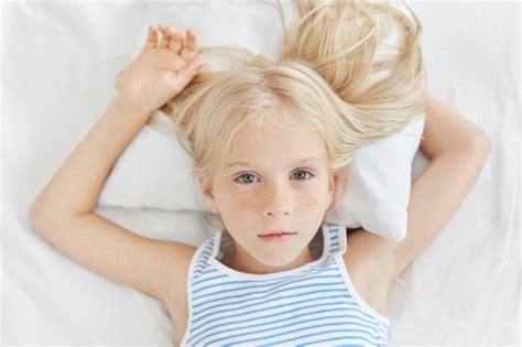 freckled blue eyed girl with blonde hair wearing striped t shirt