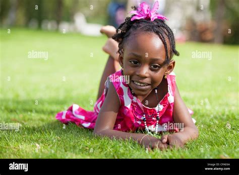 outdoor portrait of a cute little african american girl lying down on